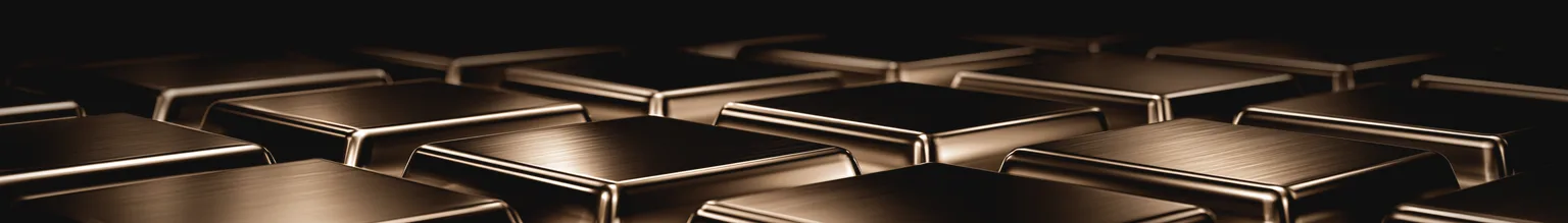 Nahaufnahme mehrerer unterschiedlicher, präzise gefertigter Metallformen aus demselben Material, in einem Licht.